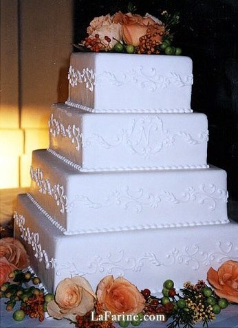 A square wedding cake with a piped monogram