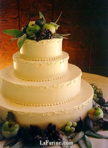 A tiered wedding cake decorated with sugared fruit